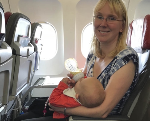 Baby trinkt Flasche im Flugzeug beim Start