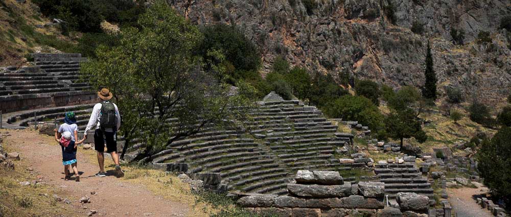 Beste Reisezeit für Griechenland mit Kindern - Familie wandert entlang altem Amphitheater